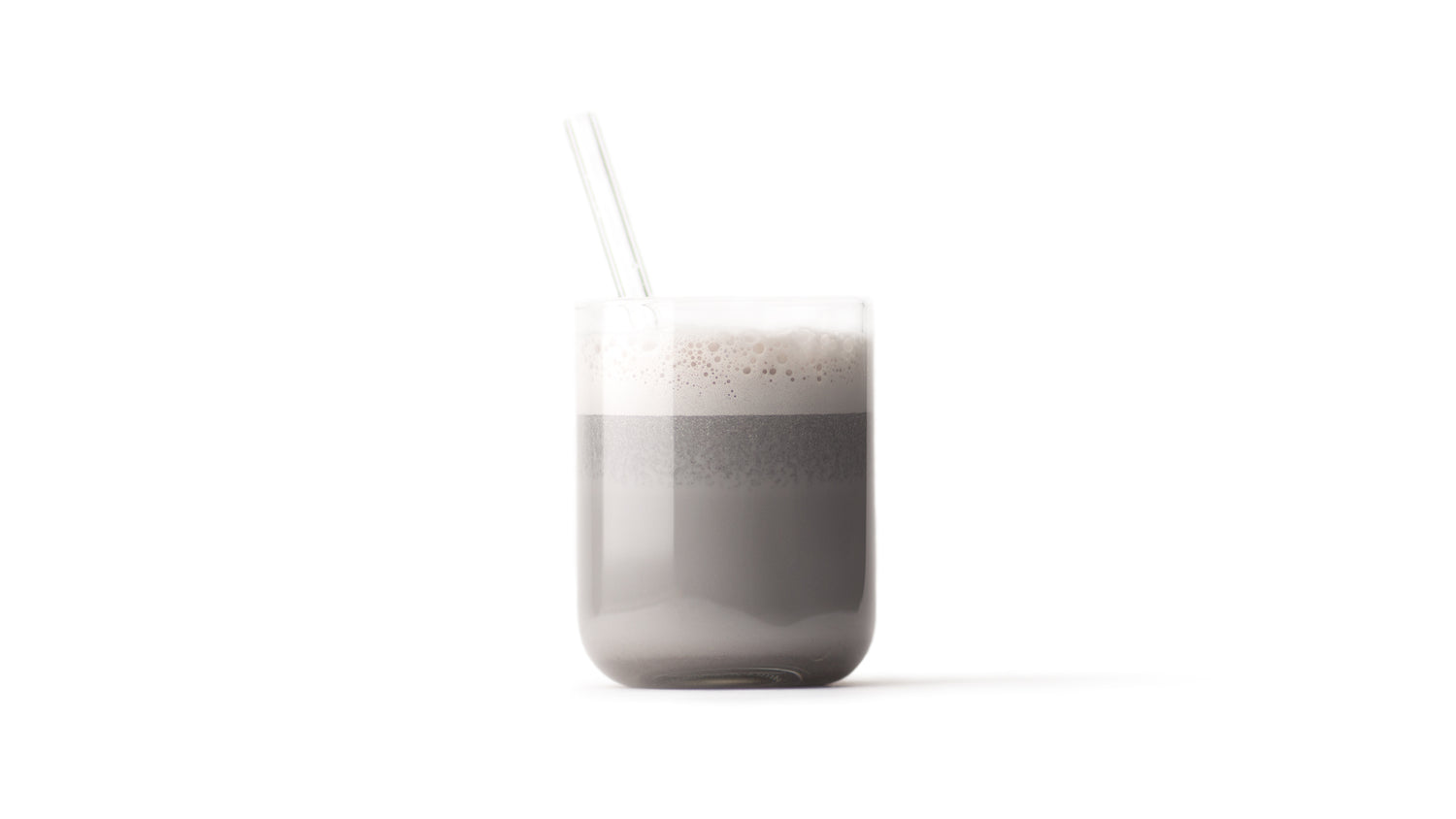 black sesame milk in a clear glass with a clear glass straw