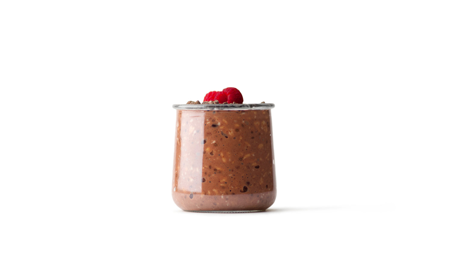 overnight cacao nibs oats in clear glass jar topped with raspberries
