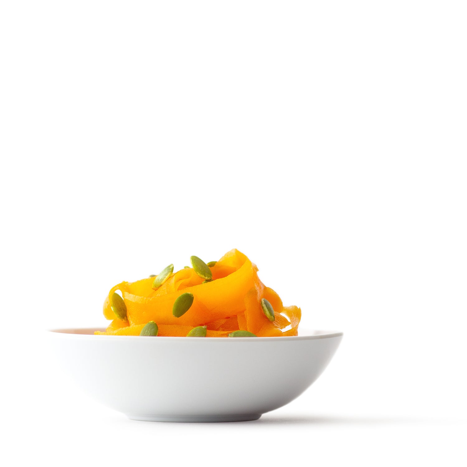 butternut squash salad with scattered pumpkin seeds in a white bowl
