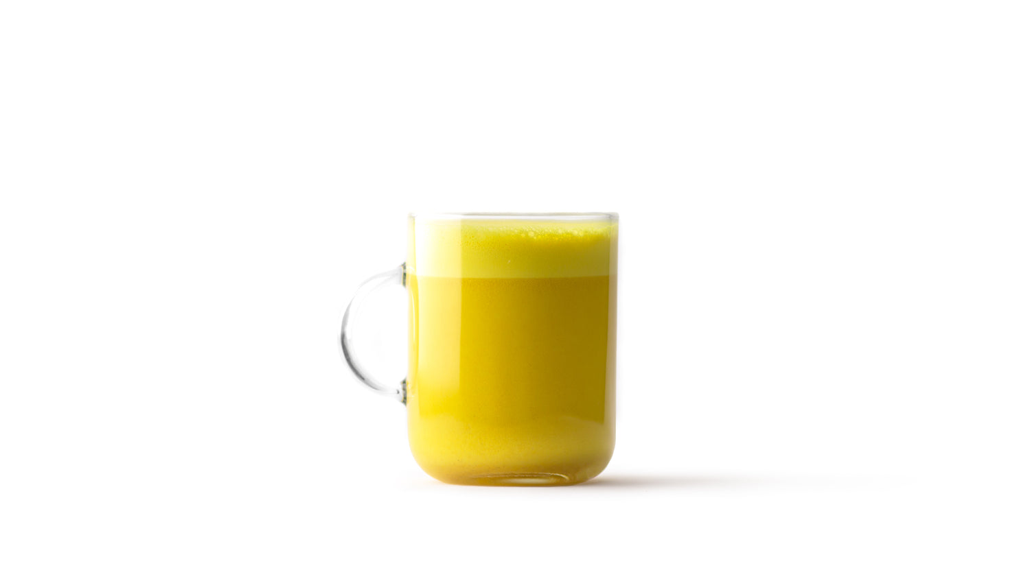 golden milk latte in a clear glass mug with a clear handle
