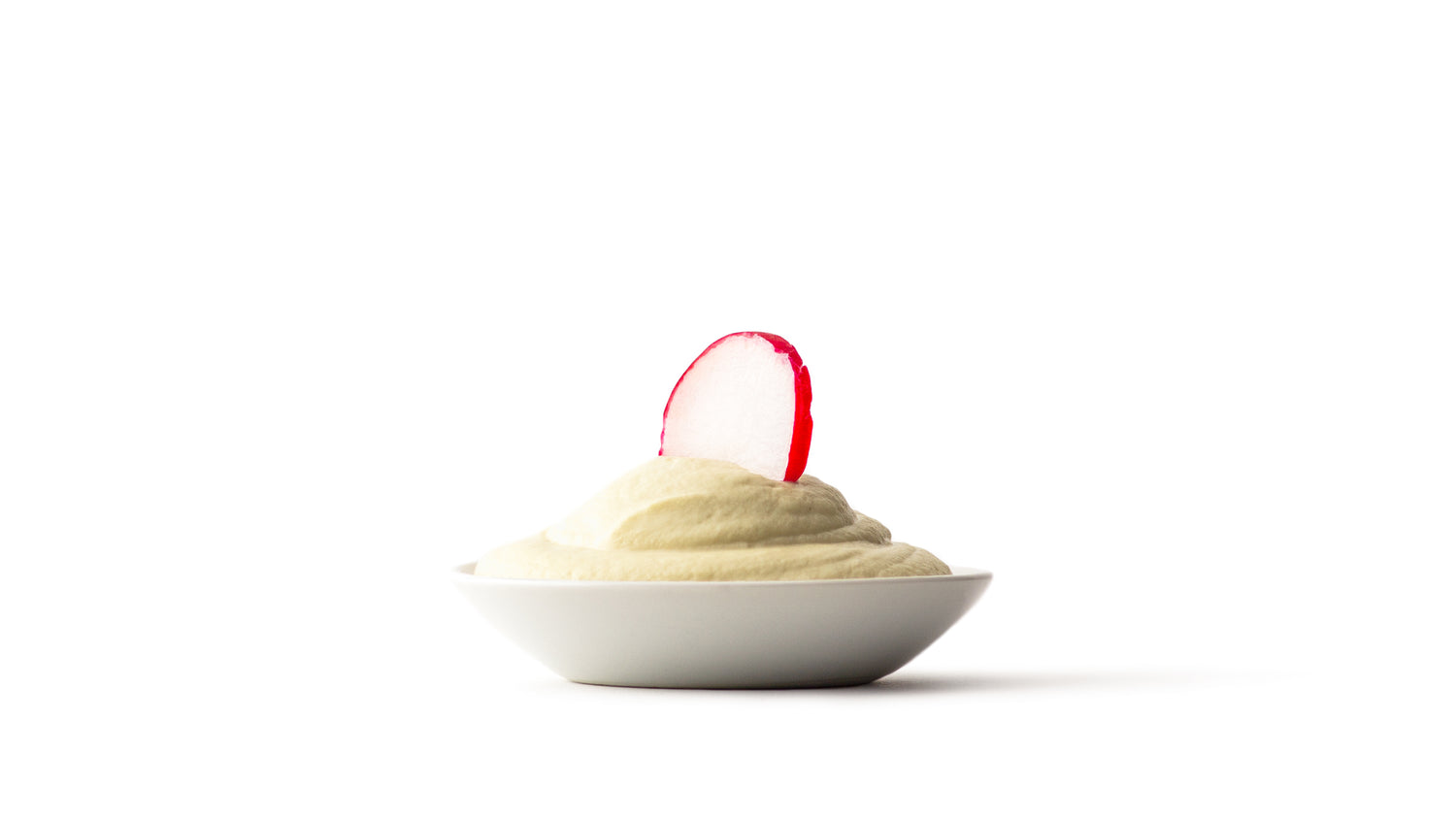 almond aioli in a white dish with a radish sticking out 