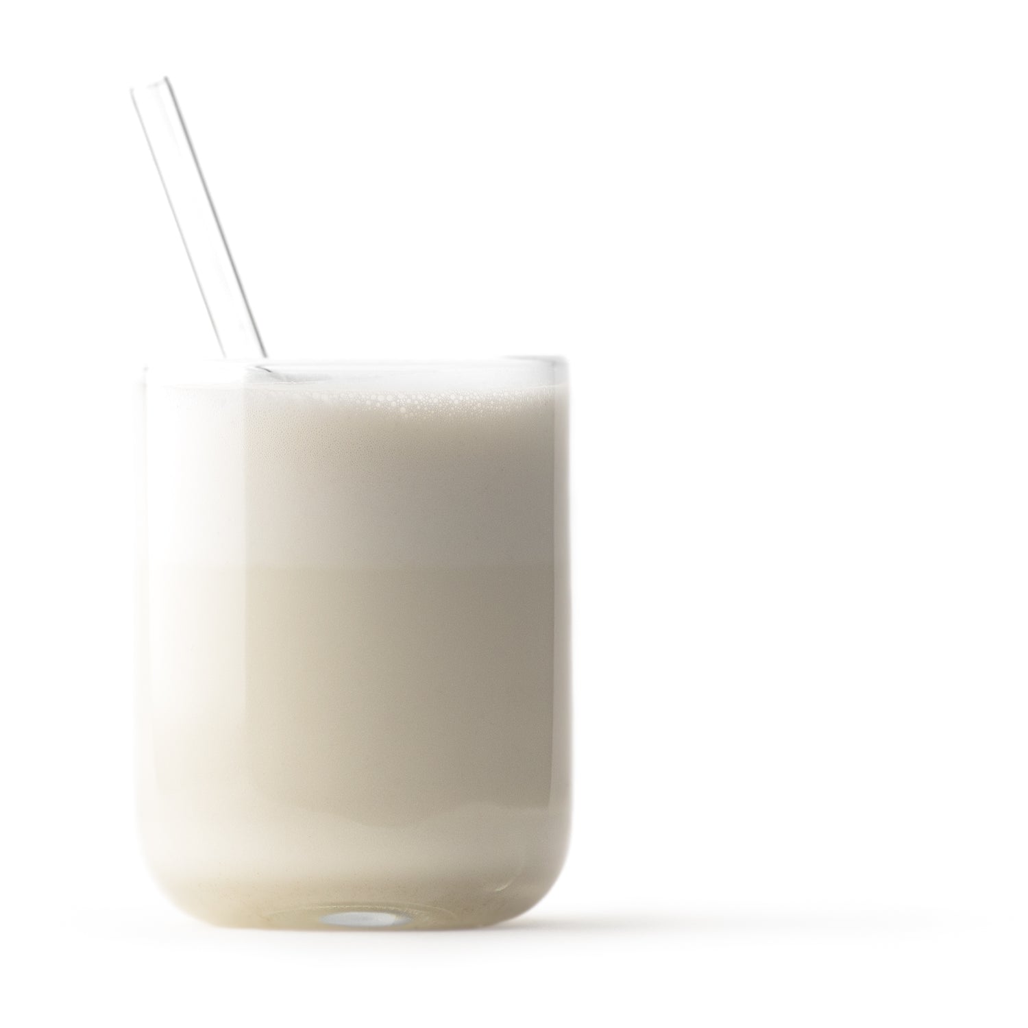 white brazil nut milk in glass cup with glass straw