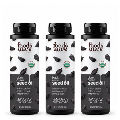 Three 8 oz black plastic bottles of Foods Alive Organic Black Cumin Seed Oil with white and charcoal labels featuring black cumin seeds. 